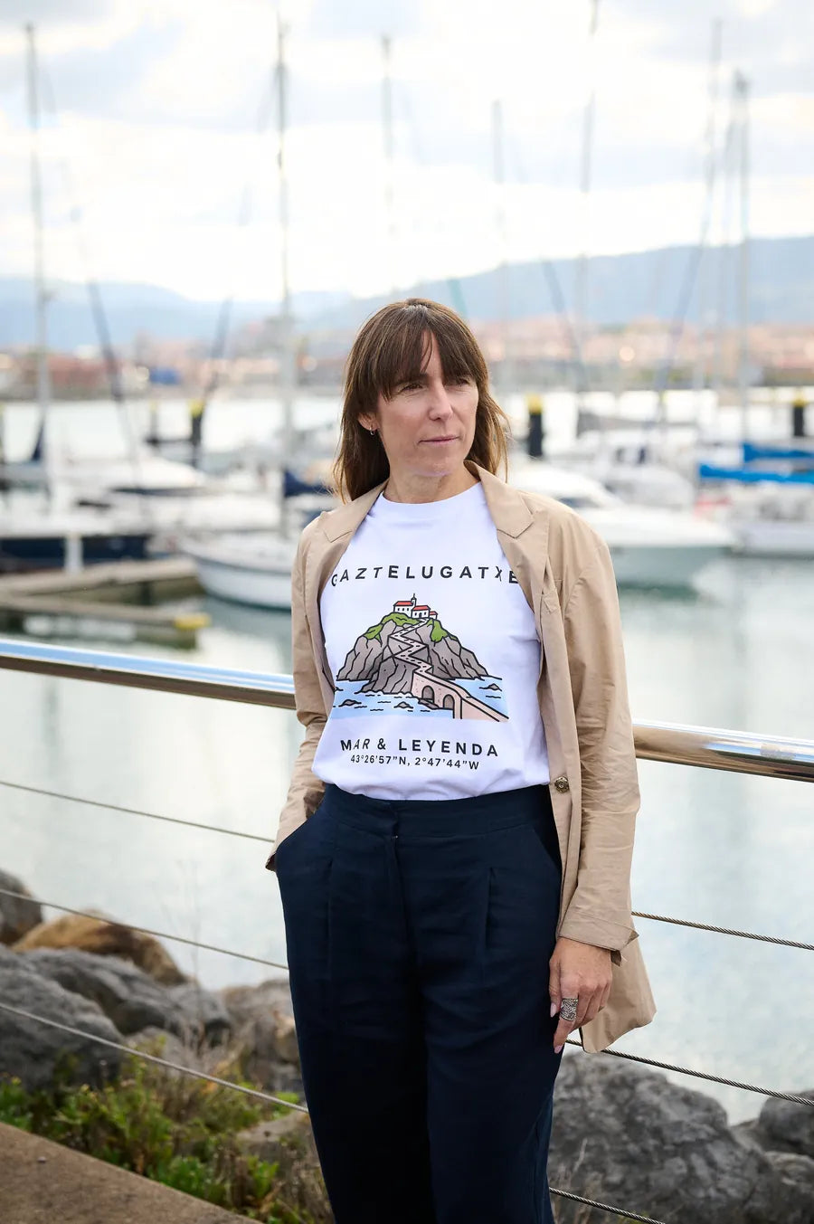 Mujer con la camiseta Gaztelugatxe · Mar & Leyenda junto al puerto deportivo