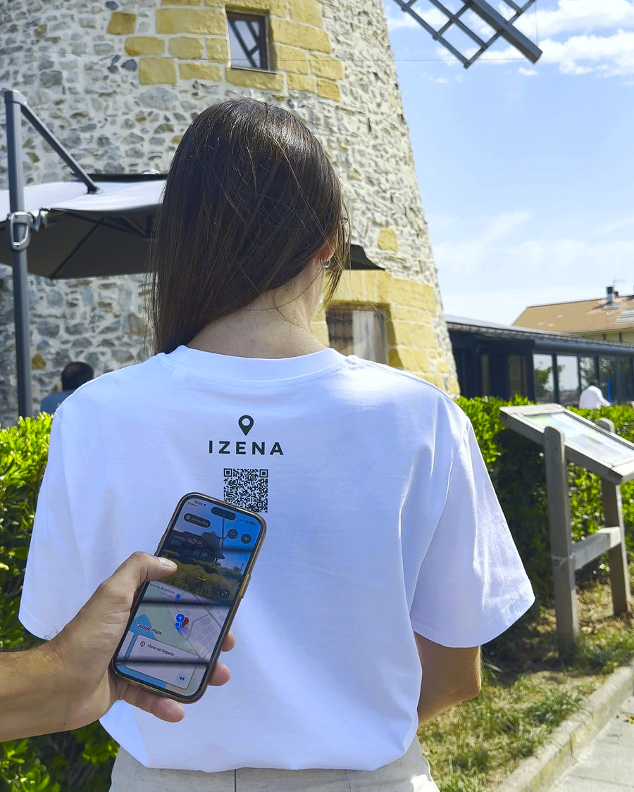Un móvil escaneando el QR de la camiseta, con el mapa abierto en la pantalla