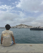 Camiseta IZENA Ibiza · Dalt Vila – sentada en el muelle, con Dalt Vila al fondo