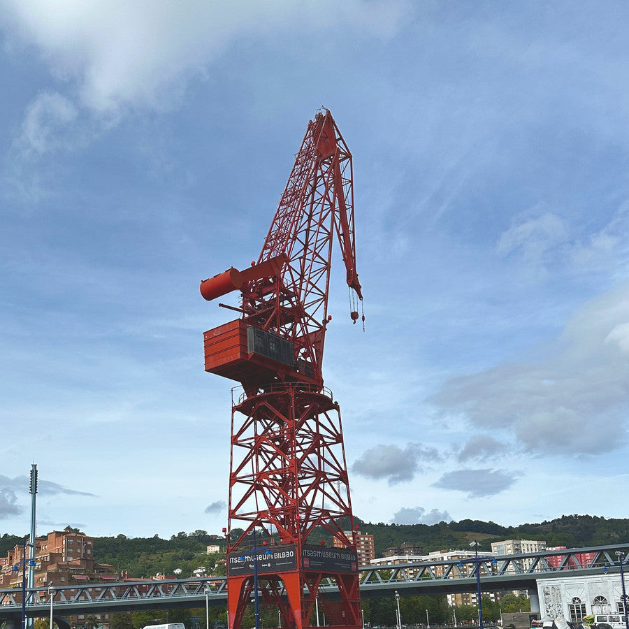 La Grúa Carola, roja, junto a la ría de Bilbao